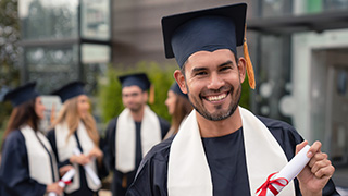 Young man graduating holding a diploma