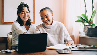 Two female students working together at one laptop